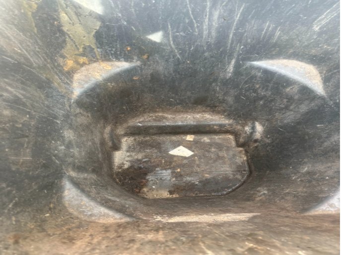 Inside of a trash barrel before cleaning, caked with baked-on grime