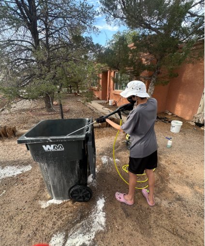 Pressure rinsing a trash barrel at the curb